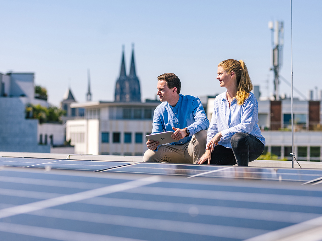 Team von Ingenieur und Ingeneurin auf Dach mit Photovoltaik-Anlage