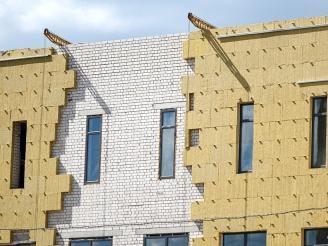 Ausschnitt einer modernen Häuserfassade mit klaren Linien und großen Fenstern