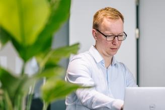 Foto eines MorgenGrün-Mitarbeiters am Laptop bei der Arbeit in einer modernen Büroumgebung
