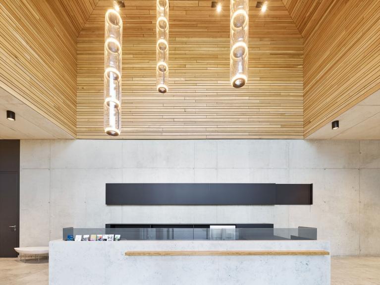 Visualisierung des Foyers eines Neubau-Bürogebäudes mit offenem Deckenbereich und funktionalem, ästhetischem Design