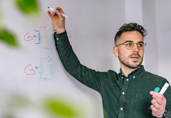 Foto eines Morgengrün Mitarbeiter der an einer Flipchart schreibt