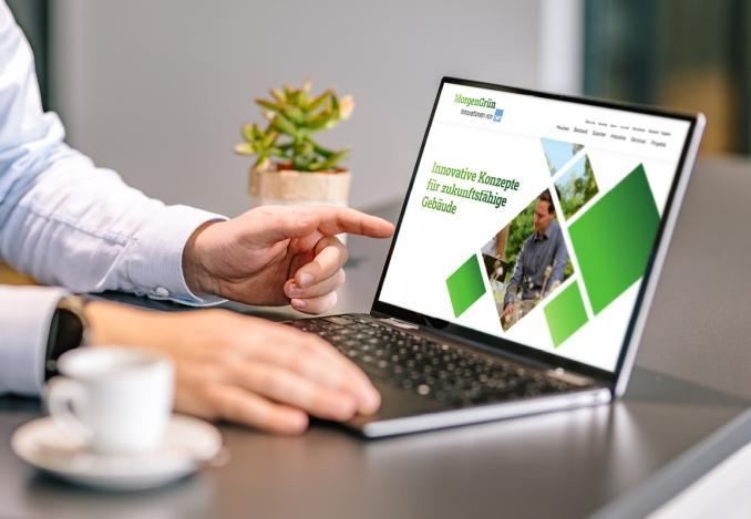 Foto eines geöffneten Laptops mit der MorgenGrün-Startseite auf dem Bildschirm in einer modernen Arbeitsumgebung