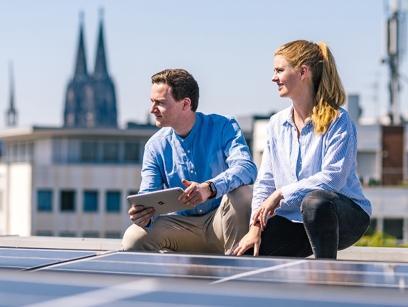 zwei Personen auf einem Dach mit einer Photovoltaik-Anlage