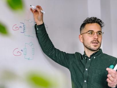 Foto eines Morgengrün Mitarbeiter der an einer Flipchart schreibt