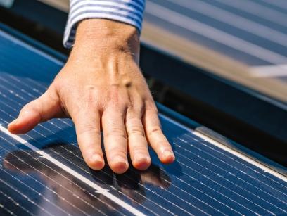 Foto einer Hand auf Photovoltaik-Anlage