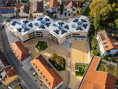 Luftaufnahme der neuen St. Martin-Grundschule in Marktoberdorf mit Schulgebäude, Außenanlagen und umliegender Umgebung